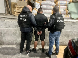 Служители на ГДБОП съпровождат задържан мъж в помещението за проверка